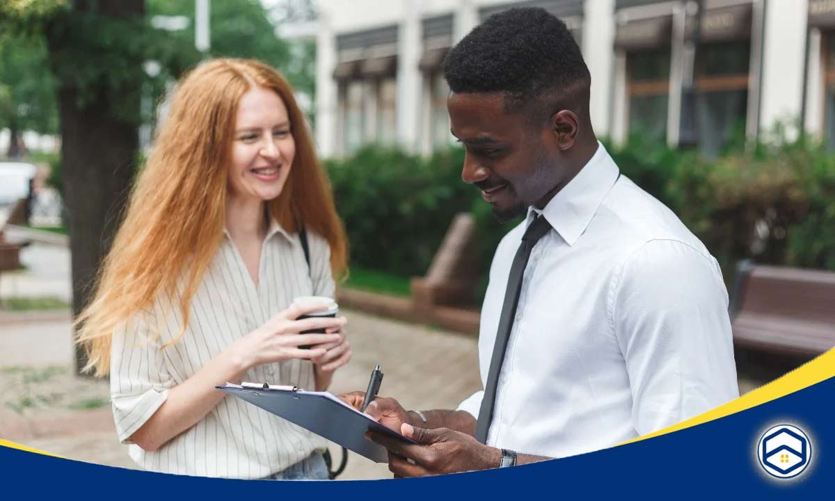 A man in a white shirt and tie writes on a clipboard while a smiling woman with tenant satisfaction metrics 