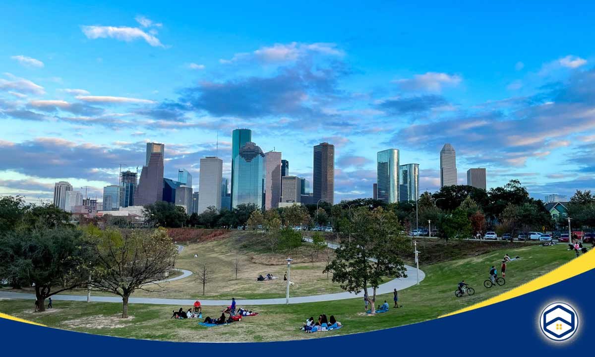 A vibrant view of the Houston skyline with people enjoying green spaces, showcasing the best neighborhoods in Houston.