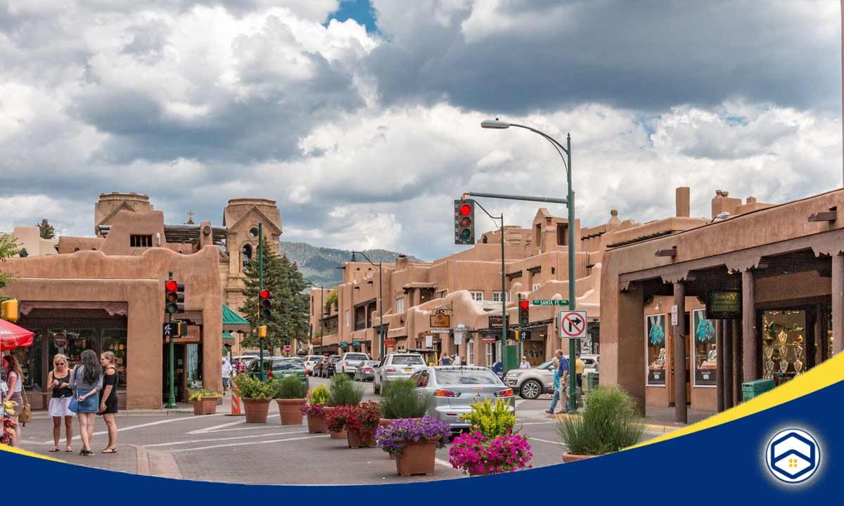 The image shows the vibrant and charming downtown area of Santa Fe, New Mexico, highlighting the unique adobe architecture, local shops and restaurants.