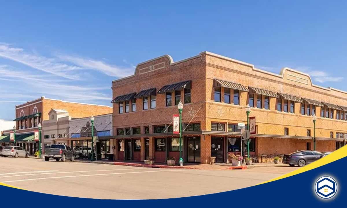 The image shows a vibrant downtown area with brick buildings, shops, and restaurants, highlighting the lively atmosphere of living in Conroe.