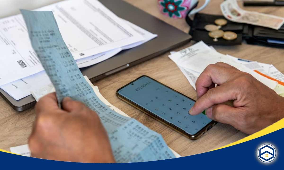 The image depicts a person using a calculator and reviewing financial documents, highlighting the cost-of-living considerations when living in Conroe. 