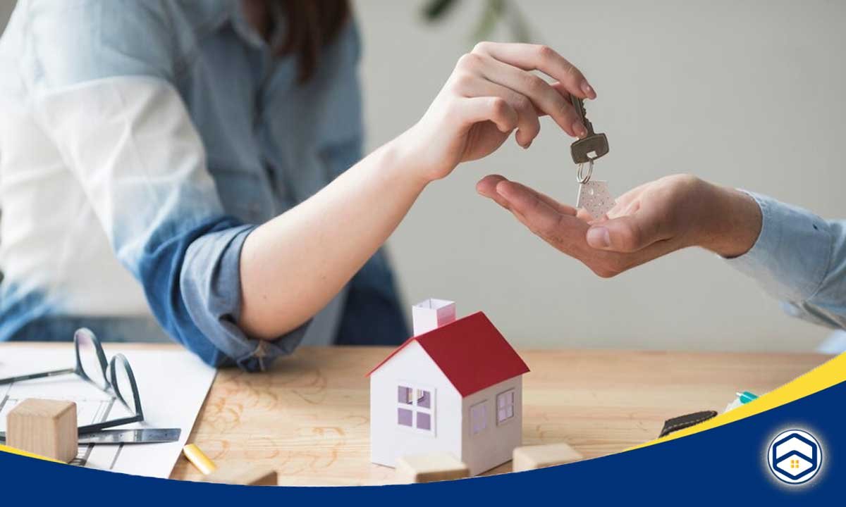 The image shows a person handing over house keys, symbolizing the process of renting or leasing a property.