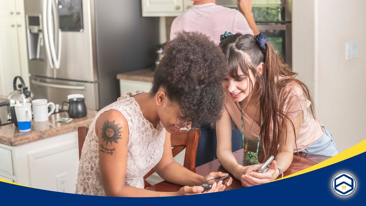 Two women smiling and discussing housing options on their phones.