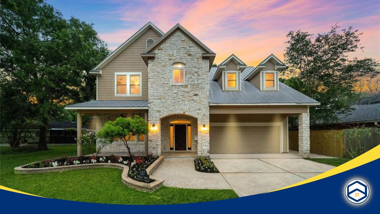 Elegant two-story house with stone and siding exterior, a well-kept front yard, and a sunset sky in the background.