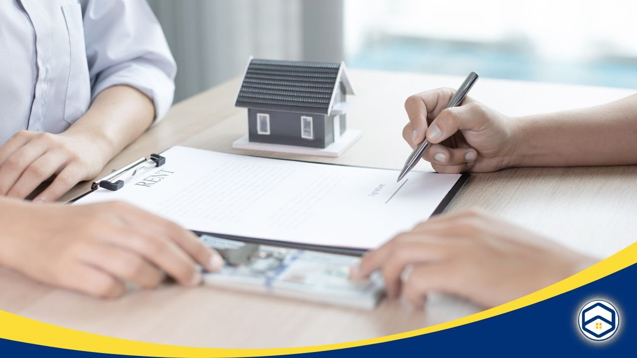 Two people discussing and signing a rental agreement with a model house on the table.