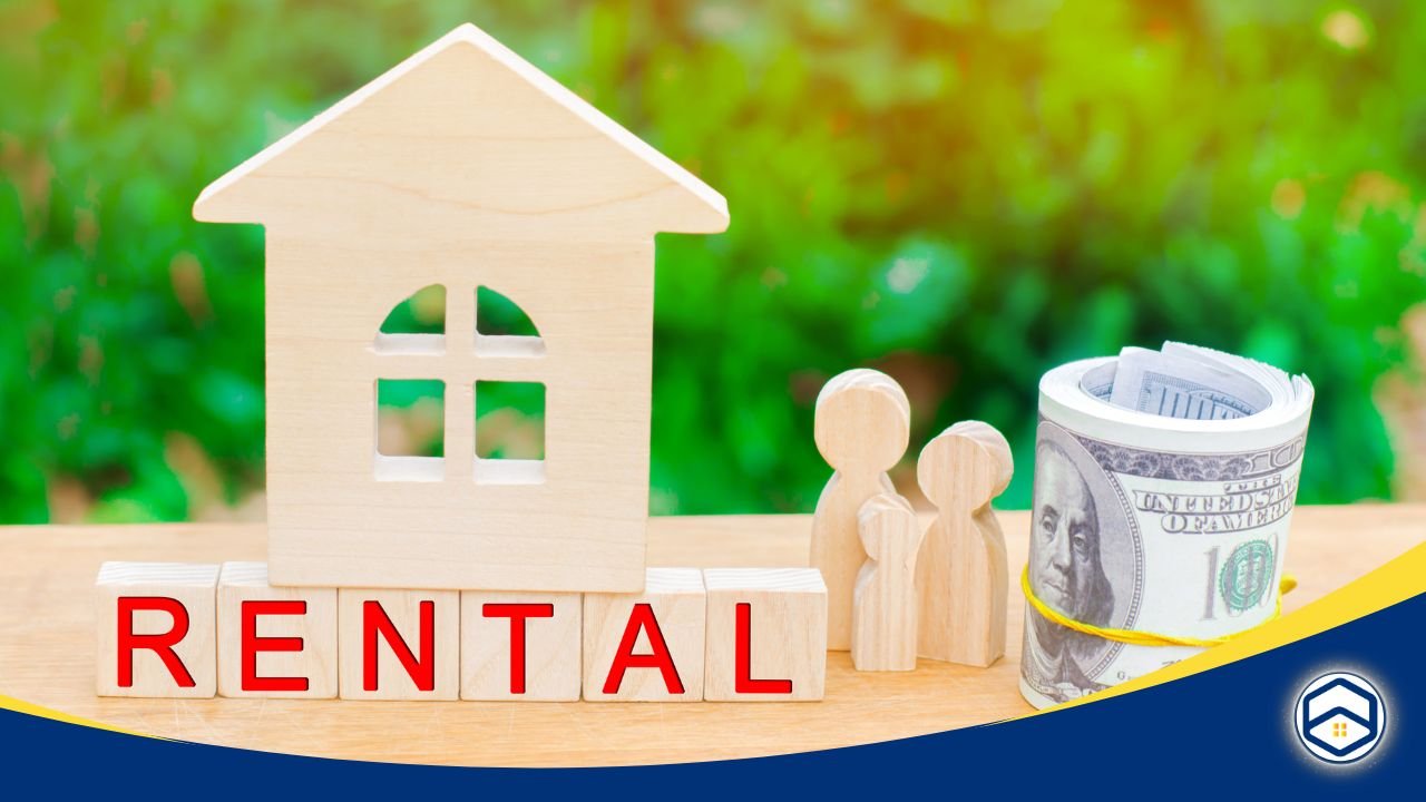 Wooden house model with 'RENTAL' blocks, wooden figures, and a rolled-up stack of money on a table.