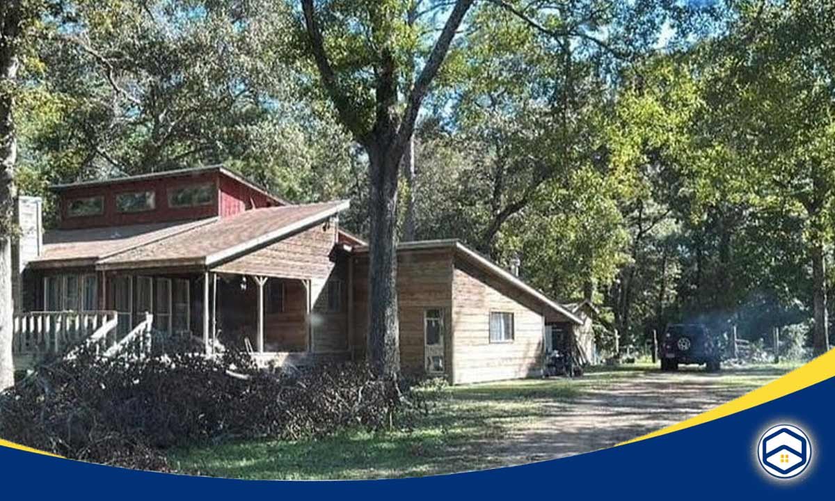 The image shows a scenic, wooded neighborhood in Adcock Acres, Conroe, Texas, which appears to be a family-friendly residential area with well-maintained homes and lush greenery.