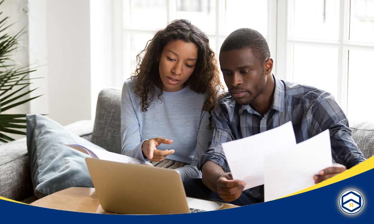 The image shows a couple reviewing documents together, likely discussing options for getting approved for an apartment or rental property despite having low credit.