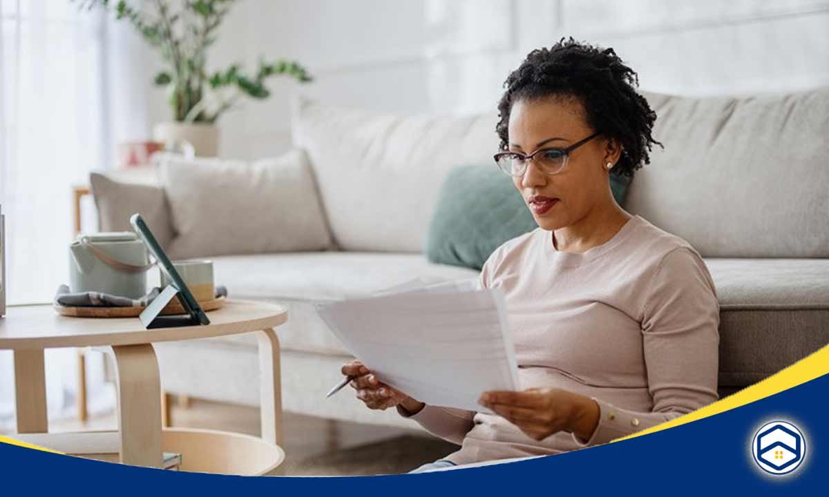 The image shows a woman sitting at a desk and using a laptop computer, which appears relevant to the topic of how to apply for an apartment in Santa Fe