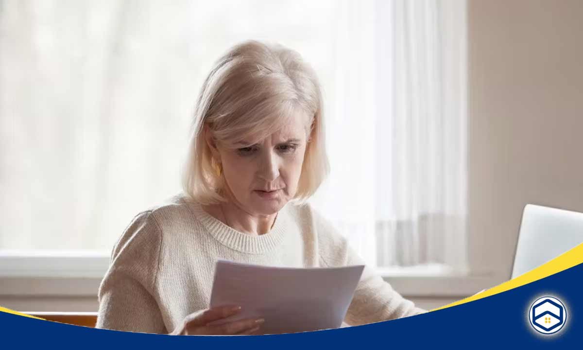 A thoughtful-looking older woman reading a document, representing the challenges faced by renters with bad credit in Santa Fe.