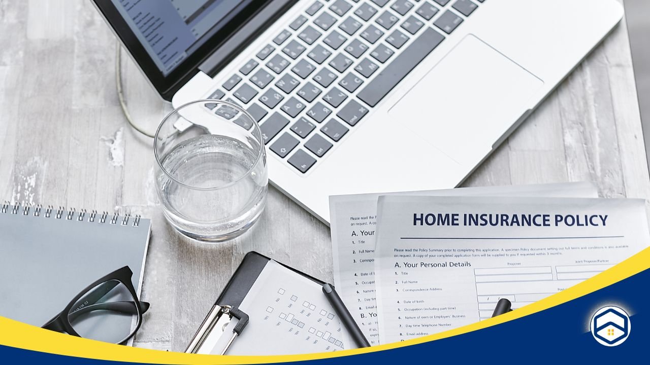 Desk with a laptop, glasses, and a home insurance policy document, emphasizing the importance of reading policy terms before signing.