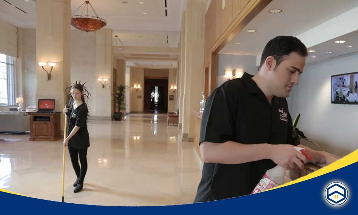 The image shows hotel staff cleaning and maintaining the lobby area, which is relevant to a blog post about hospitality cleaning schedules in Conroe.