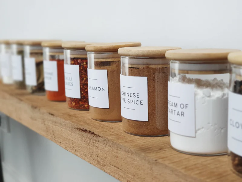 A row of labeled jars neatly arranged on a floating shelf, adding organization and efficiency to the kitchen.