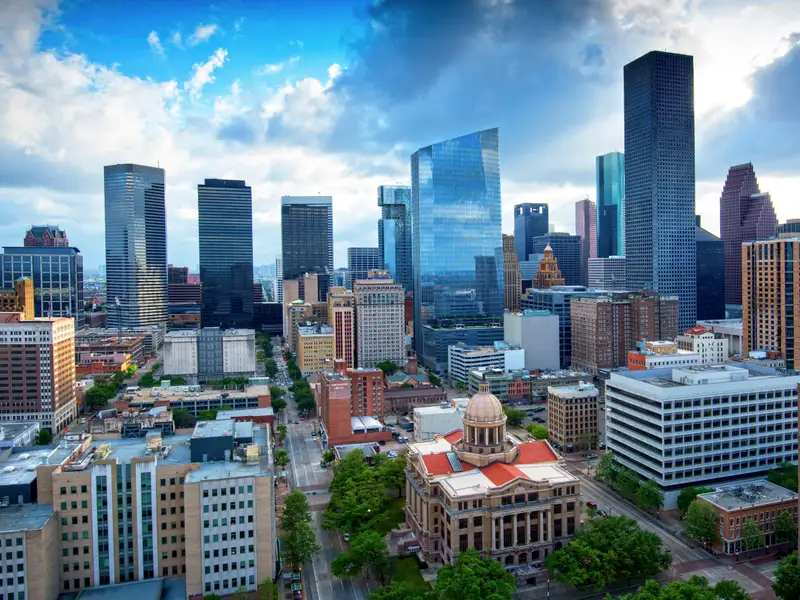 Aerial view of the downtown Houston skyline showcasing modern glass skyscrapers and clean architectural lines, symbolizing the minimalist movement in urban design and lifestyle.